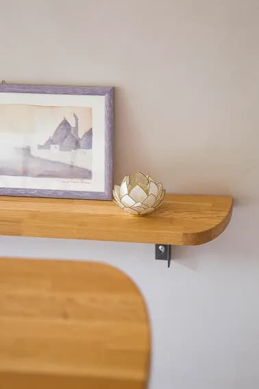Floating oak shelf with a framed watercolour print and a shell-shaped ornament