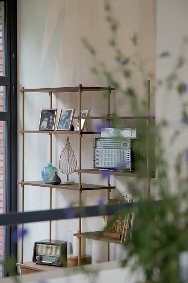 Mid-century shelving unit styled with framed photographs, ceramics and a vintage radio