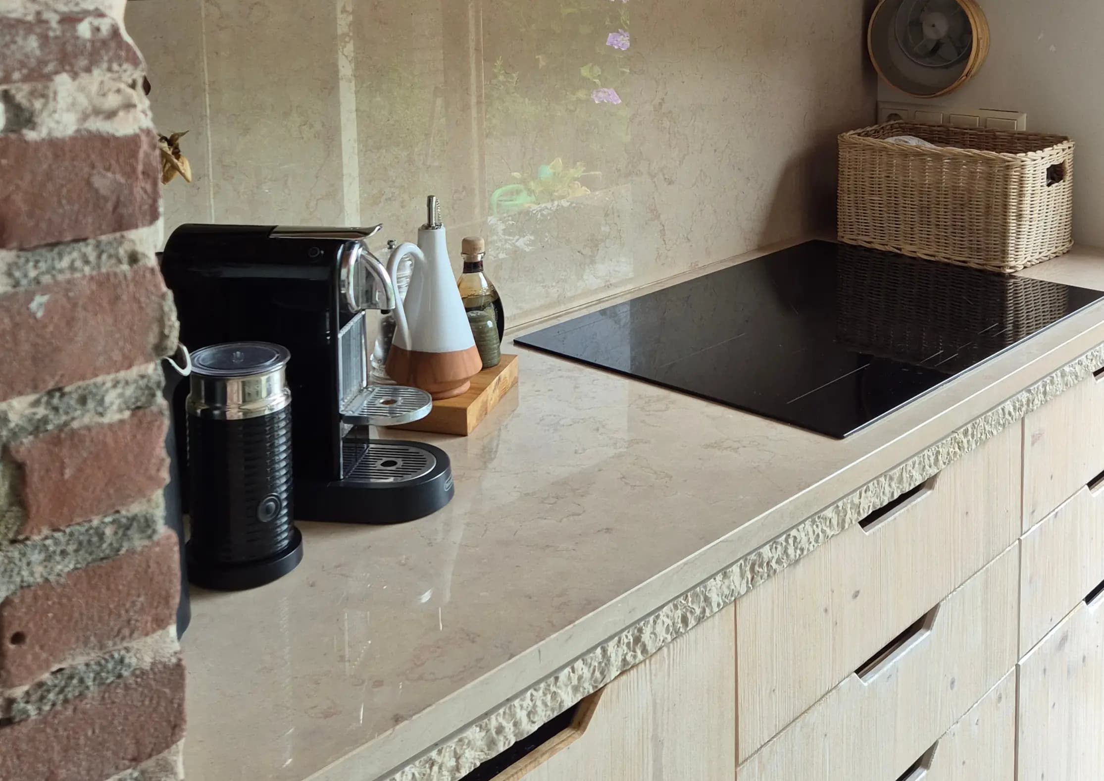 A warm kitchen corner in Sandra's own home, exposed brick beside a marble countertop